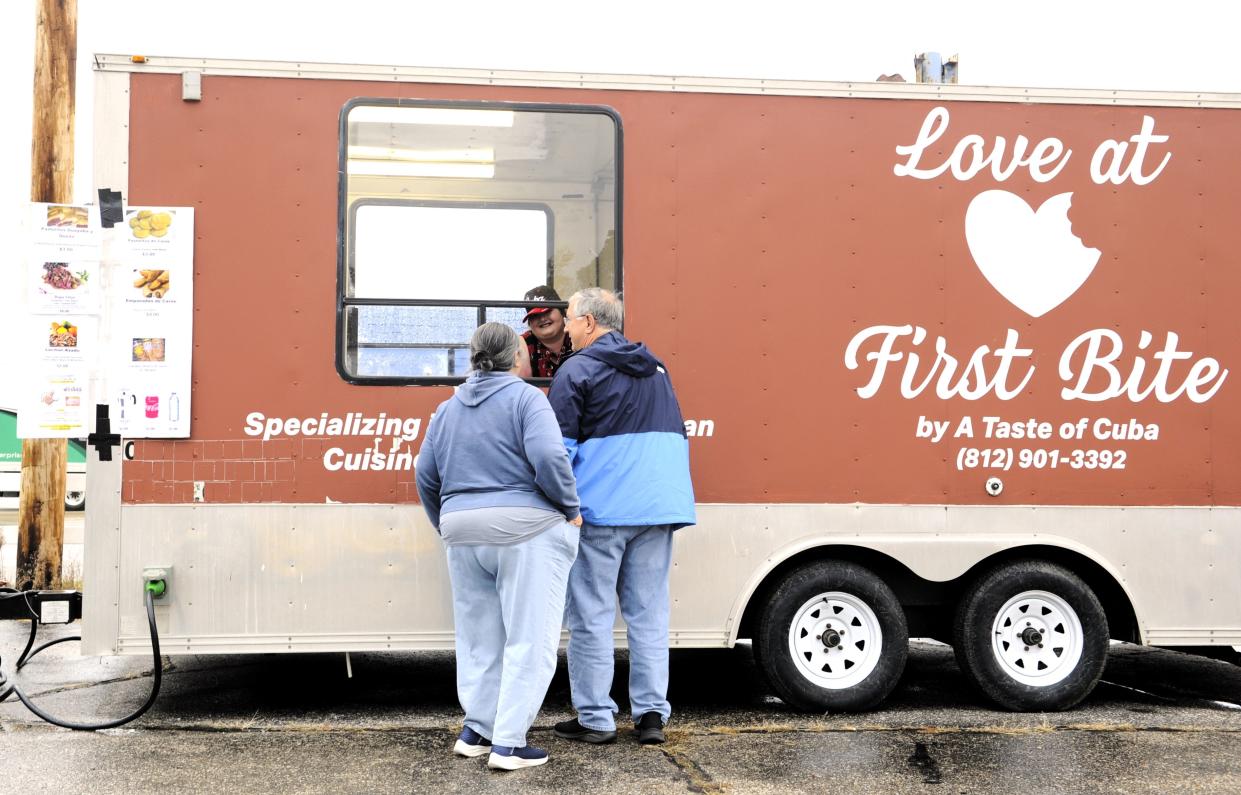Barbara DeJarnett serves customers Soi and Mark Powell at the Love at First Bite by A Taste of Cuba food truck on Friday, Nov. 17, 2023.