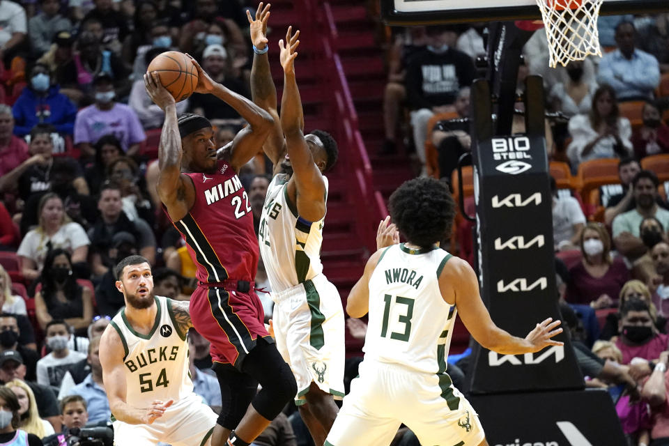 Miami Heat forward Jimmy Butler (22) looks to pass the ball as Milwaukee Bucks forward Sandro Mamukelashvili (54) and forward Jordan Nwora (13) defend during the first half of an NBA basketball game, Thursday, Oct. 21, 2021, in Miami. (AP Photo/Lynne Sladky)