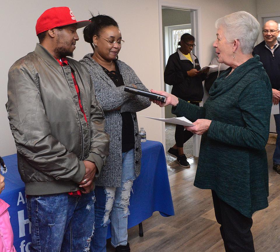 Lawrence and Kelly Williams receive a Bible from Alliance Area Habitat for Humanity board member Lynda Slack during the dedication service Sunday, Dec. 17, 2023, when the family received the keys to their new home in Alliance.