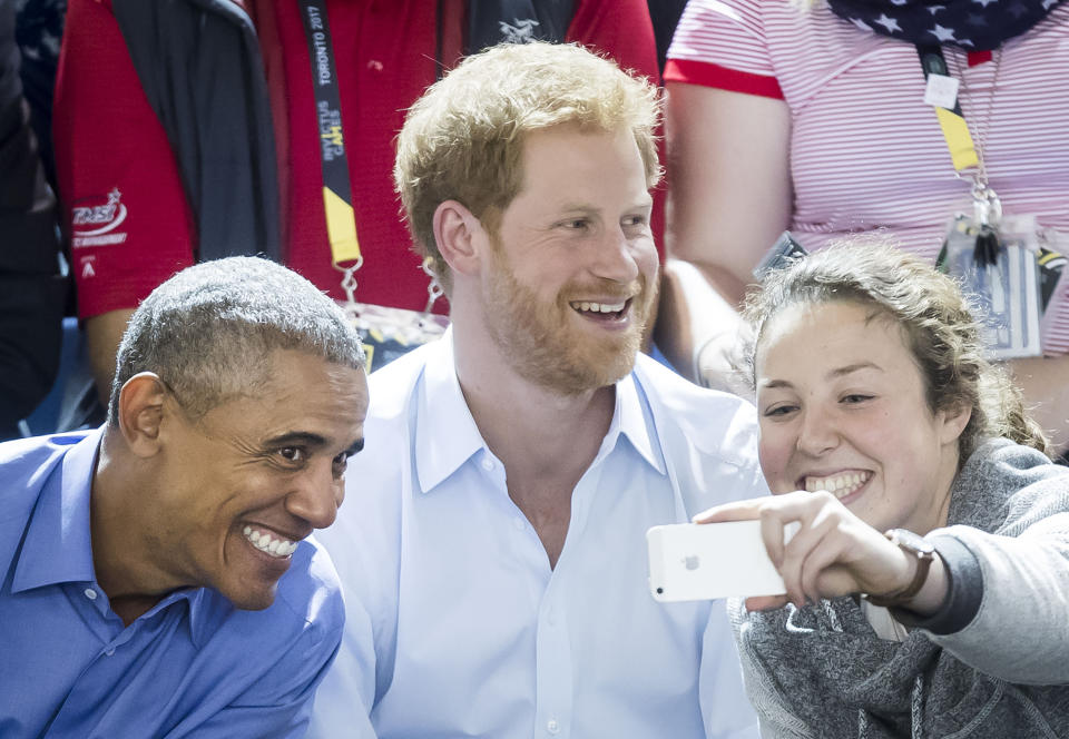 A woman takes a selfie with Obama and Prince Harry at the 2017 Invictus Games. (Photo: Danny Lawson - PA Images via Getty Images)