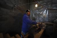 Tranquilino Gabriel works on decorative wood spindles on a primitive lathe using a nail-studded piece of wood, in the Puerpecha Indigenous community of Comachuen, Michoacan state, Mexico Wednesday, Jan. 19, 2022. The 59-year-old does this only on his downtime from working in the U.S., to keep his decades-old family business alive. (AP Photo/Fernando Llano)