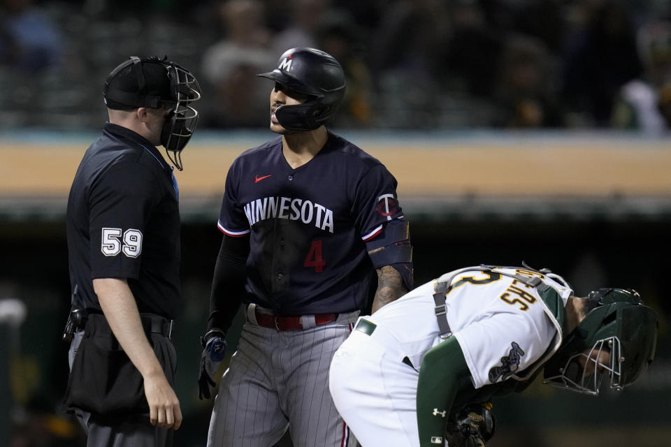 Minnesota Twins' Carlos Correa (4) speaks to home plate umpire Nic Lentz, left, after being called out on strikes during the sixth inning of the team's baseball game against the Oakland Athletics on Friday, July 14, 2023, in Oakland, Calif. (AP Photo/Godofredo A. Vásquez)