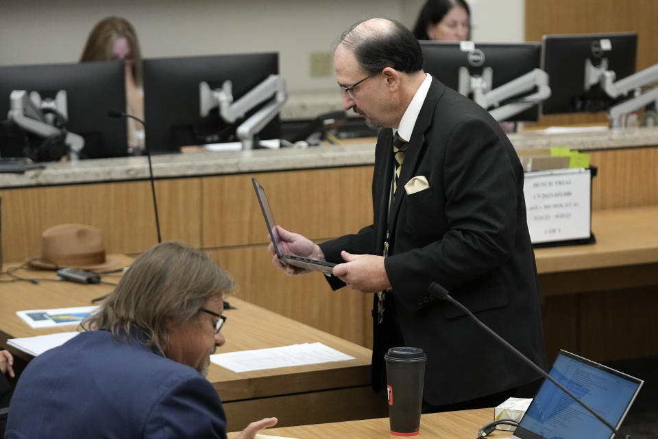 Attorney Joseph La Rue, right, representing Maricopa County, walks past attorney Bryan Blehm, left, representing former Arizona Republican candidate for governor Kari Lake, during the second day of the two-day bench trial brought by Lake regarding a voting records request, Monday, Sept. 25, 2023, in Phoenix. (AP Photo/Ross D. Franklin, Pool)