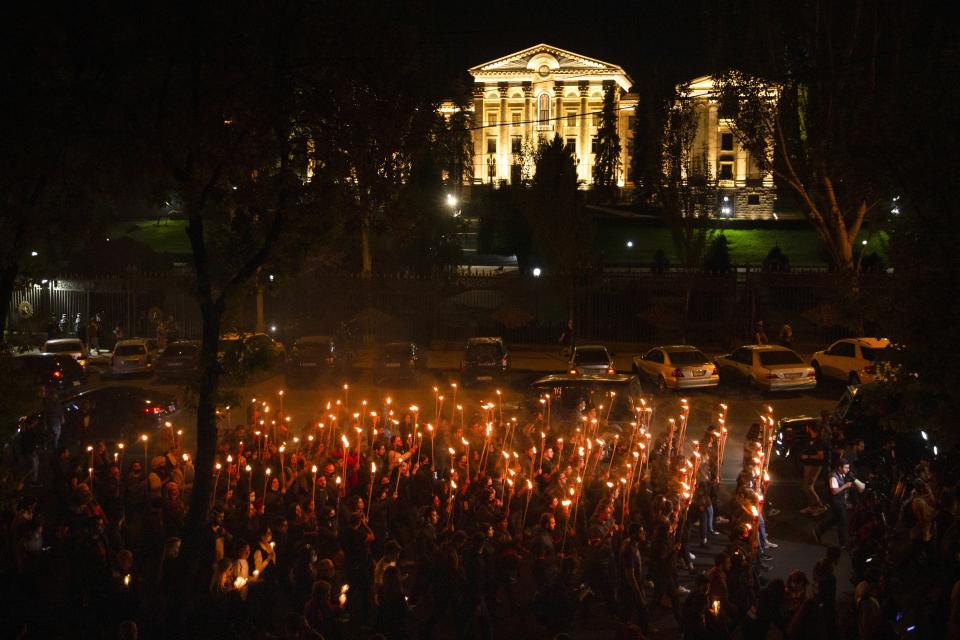 Torchlight procession march during a demonstration to mark the 106th anniversary of the massacre and honors the victims of Armenian Genocide, with the Government buildings in the background in Yerevan, Armenia, Saturday, April 24, 2021. Armenians marked the anniversary of the death of up to 1.5 million Armenians by Ottoman Turks, an event widely viewed by scholars as genocide, though Turkey refutes the claim. (Grigor Yepremyan/PAN Photo via AP)