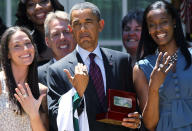 <p>President Barack Obama (C) shows off a champion ring which he receives as a gift with Seattle Storm's forward guard Sue Bird (L) Coach Brian Agler (2nd L) and Swin Cash (R) during a Rose Garden event June 29, 2011 at the White House in Washington, DC. Obama hosted the WNBA Champion at the White House to honor the team's 2010 championship season. (Alex Wong/Getty Images) </p>