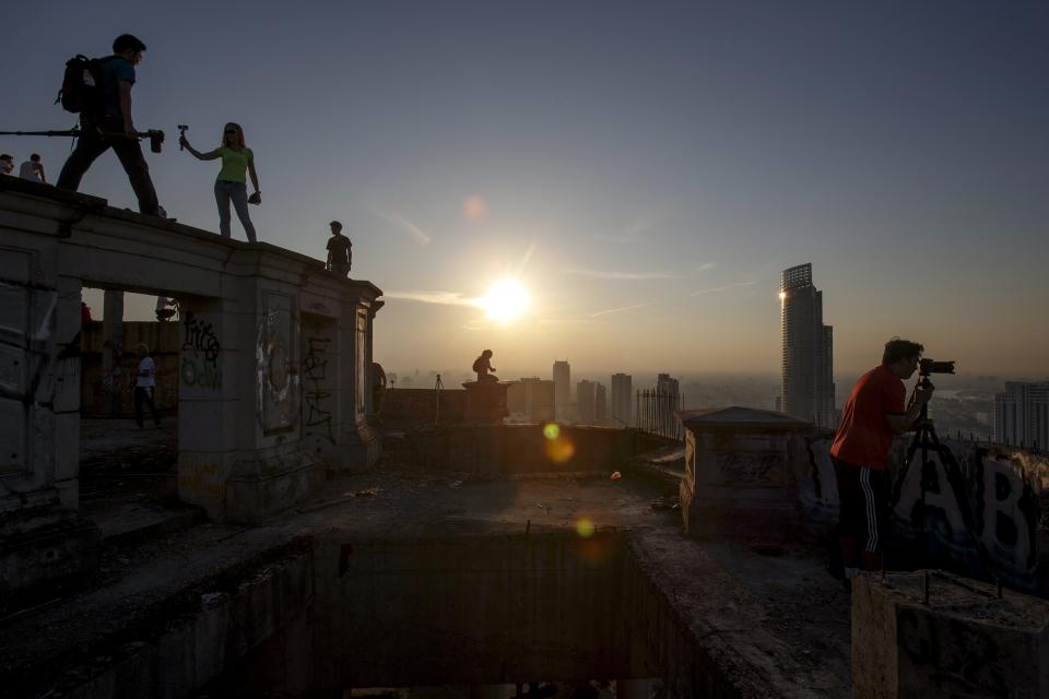 Visitors enjoy the sunset on the roof top of an abandoned building in Bangkok