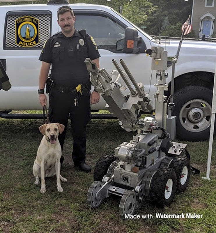 In this undated photo released by the Columbia, S.C. Police Department, Master Police Officer David Hurt is seen with his police dog "Turbo." Hurt was suspended without pay for five days after Turbo died from excessive heat in July 2018 when the dog was left in a police vehicle for more than six hours. (Columbia, S.C. Police Department via AP)