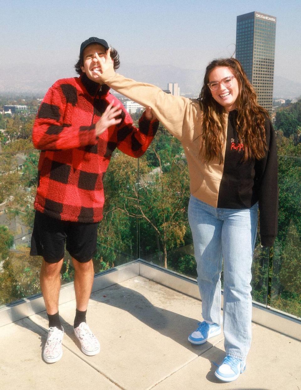 Influencers David Dobrik and Natalie Mariduena wearing Unxpectd’s “Smile!” sherpa and “Don’t Be A Puppet” split hoodie.