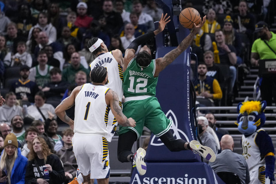 Boston Celtics forward Oshae Brissett (12) is fouled as he shoots by Indiana Pacers guard Andrew Nembhard (2) during the first half of an NBA basketball game in Indianapolis, Monday, Jan. 8, 2024. (AP Photo/Michael Conroy)