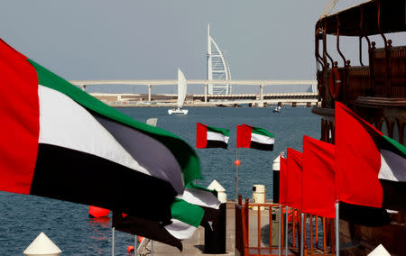 FILE PHOTO: United Arab Emirates (UAE) flags fly as the Burj al-Arab luxury hotel is seen in the background during the UAE's National Day in Dubai December 2, 2009. REUTERS/Ahmed Jadallah/File Photo