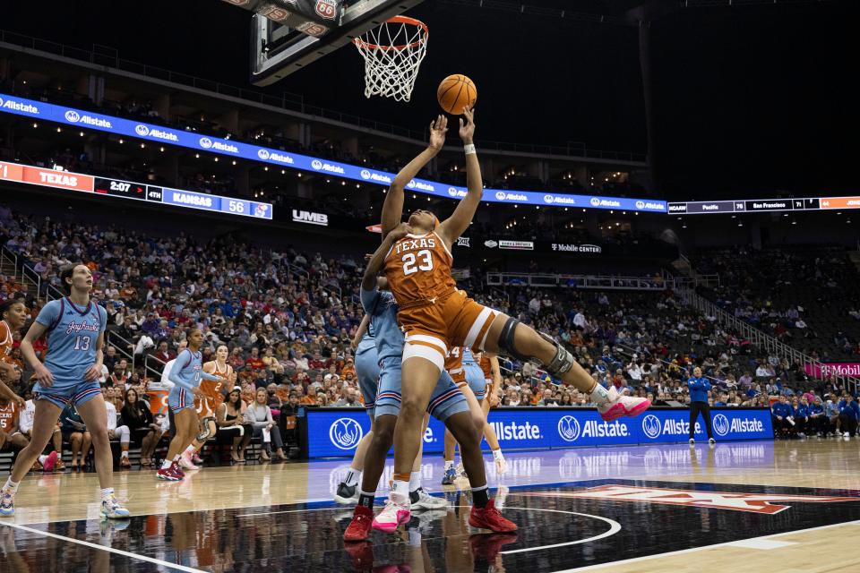 Texas forward Aaliyah Moore tries to get off a shot against Kansas guard Zakiyah Franklin during the second half of the Longhorns' 76-60 win in Saturday's Big 12 Tournament quarterfinals. Moore finished with 19 points and 11 rebounds.