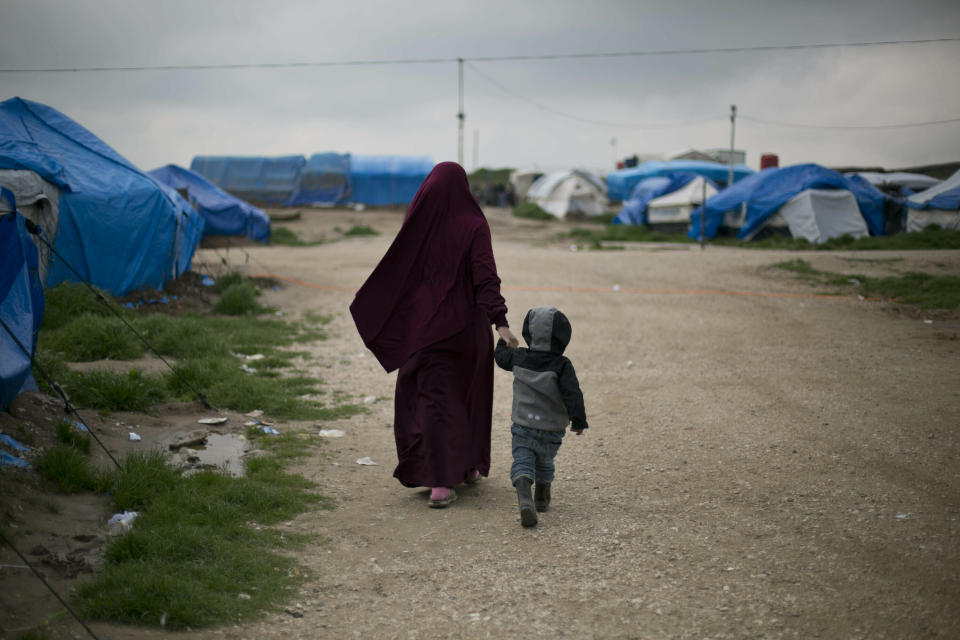 In this March 27, 2019, photo, Samira from Belgium walks with her son at Camp Roj in north Syria. She traveled to Syria, where Islamic State militants brought suitors for marriage. Samira chose a French citizen, Karam El-Harchaoui. Her husband now imprisoned for IS ties, she is trying to get home to Belgium. “What we saw with Daesh was a lesson to us and allowed us to gain perspective on the extremists. All we want is to reintegrate in our society,” she said, using an Arabic acronym for IS. (AP Photo/Maya Alleruzzo)