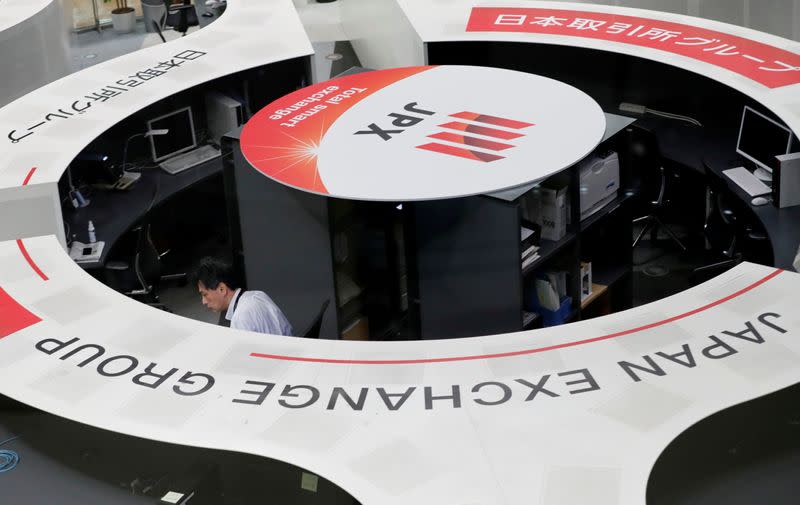 FILE PHOTO: A man works at the Tokyo Stock Exchange after market opens in Tokyo