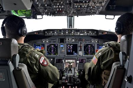 Lieutenant Clayton Hunt and Lieutenant (junior grade) Nicholas Horton, naval aviators assigned to Patrol Squadron (VP) 16, pilot a P-8A Poseidon during a mission to assist in search and rescue operations for Malaysia Airlines flight MH370 in this March 24, 2014 handout photo. REUTERS/Mass Communication Specialist 2nd Class Eric A. Pastor/U.S. Navy/Handout via Reuters