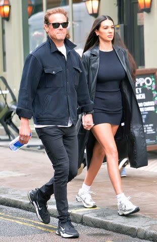 <p>WJ_Images/Eden / BACKGRID</p> Sam Heughan holds hands with a woman in London on May 29