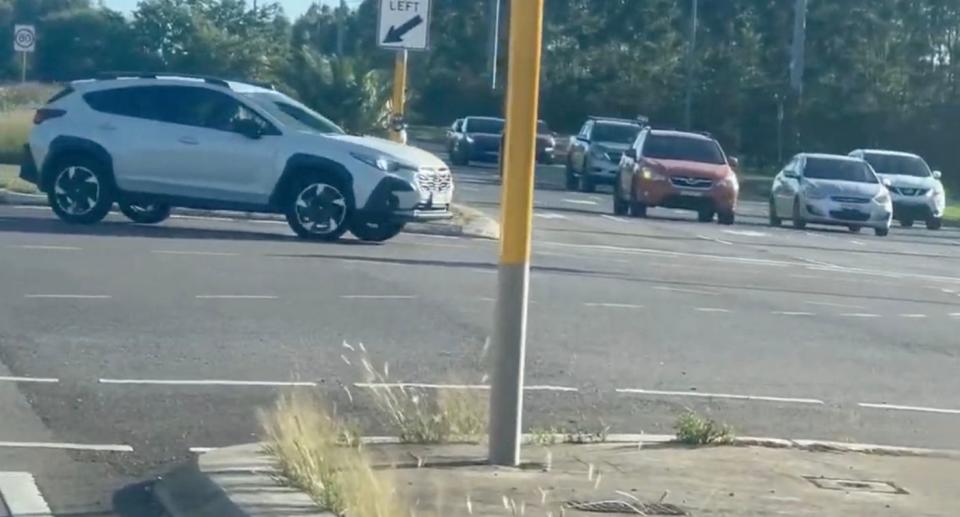 The slow-moving vehicle displayed its hazard lights as it entered the busy intersection. Source: Facebook