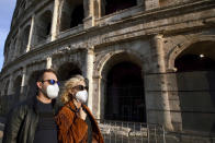 People wearing masks walk past the ancient Colosseum in Rome, Tuesday, Oct. 13, 2020. Italian Premier Giuseppe Conte says the aim of Italy’s new anti-virus restrictions limiting nightlife and socializing is to head off another generalized lockdown. Conte defended the measures as both “adequate and proportional” to the current need. He spoke Tuesday as the health ministry reported another 5,901 people tested positive over the past day and 41 people died, bringing Italy’s official COVID-19 death toll to 36,246, the second highest in Europe after Britain. (AP Photo/Andrew Medichini)