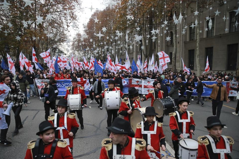 Georgians with EU and national flags gather to celebrate Georgia's EU candidacy at the Rustaveli street in Tbilisi, Georgia, on Friday, Dec. 15, 2023. Several thousand people attend a march in support of Georgia's EU candidacy. European Union flags waved across Georgia Friday after the European Council took a step forward along the long road towards granting Georgia and Moldova as EU membership. (AP Photo/Zurab Tsertsvadze)