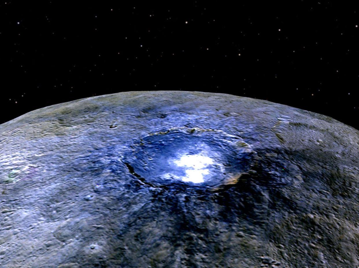 This representation of Ceres' Occator Crater in false colours shows differences in the surface composition. Scientists use the false colour as a way of examining the way that the surface is composed: NASA/JPL-Caltech/UCLA/MPS/DLR/IDA