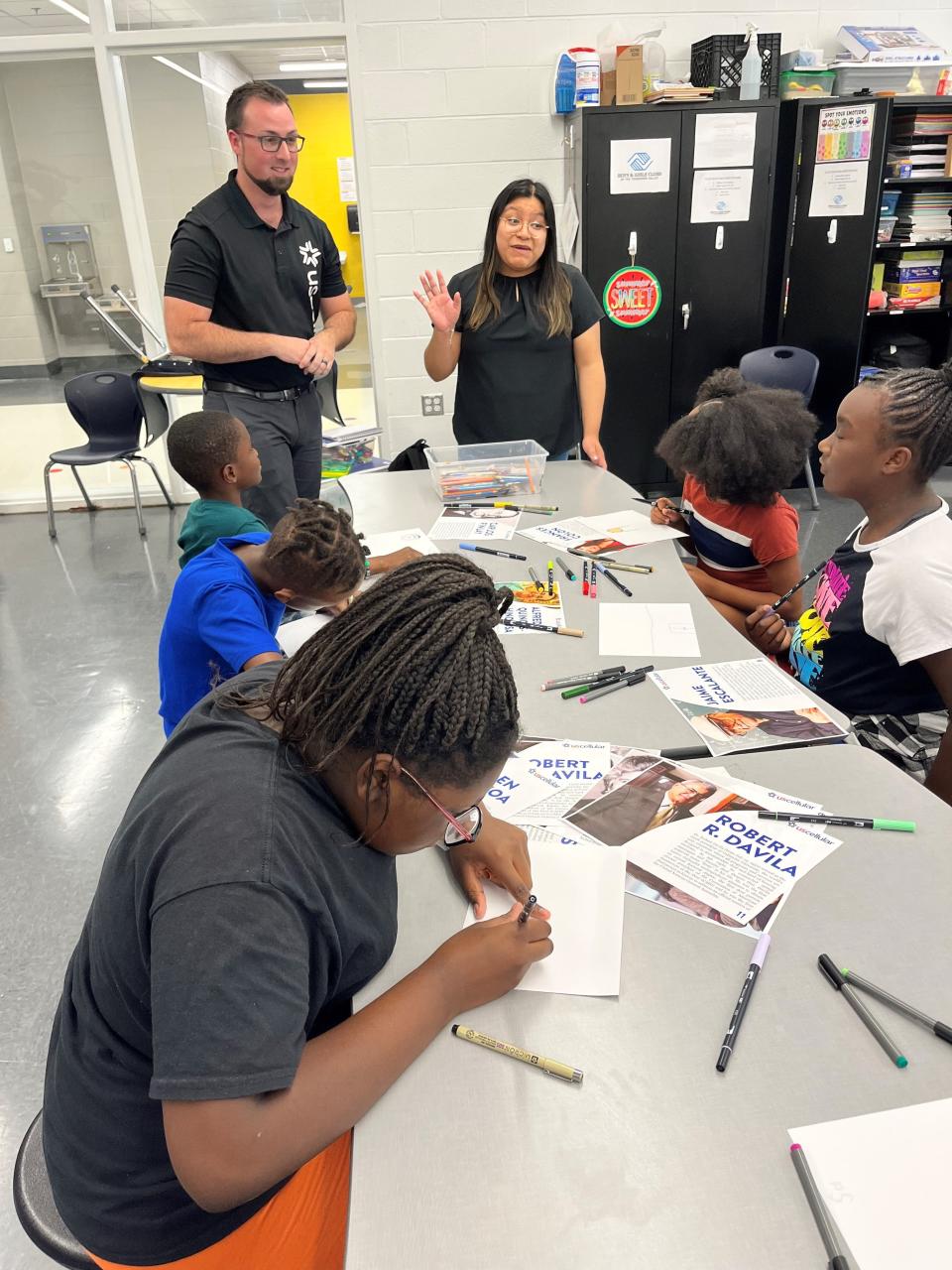 Andrew Schmenger and Angela Jimenez of UScellular oversee the activity as Giannah Williams, Gu'elz Hinez, Losine Kromah, Malejah Marsh and Iyah Groce work busily on their artwork for the first Hispanic Heritage Art Contest kickoff event at the Lonsdale location of the Boys & Girls Club of the Tennessee Valley. Aug. 31, 2023