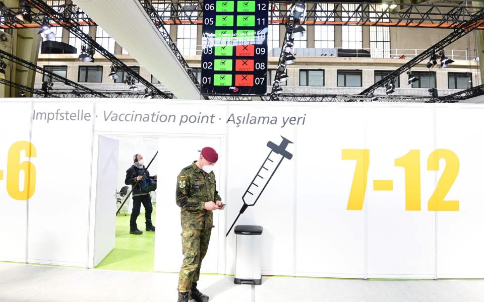 A soldier of the German Armed Forces Bundeswehr stands inside a new vaccination centre at the former Tempelhof airport in Berlin before its opening on March 8, 2021. (Photo by Tobias Schwarz / various sources / AFP) (Photo by TOBIAS SCHWARZ/POOL/AFP via Getty Images) -  TOBIAS SCHWARZ/AFP