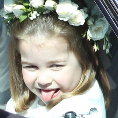 Princess Charlotte cheekily sticks her tongue out as she arrived at the wedding - Credit: Andrew Milligan/PA