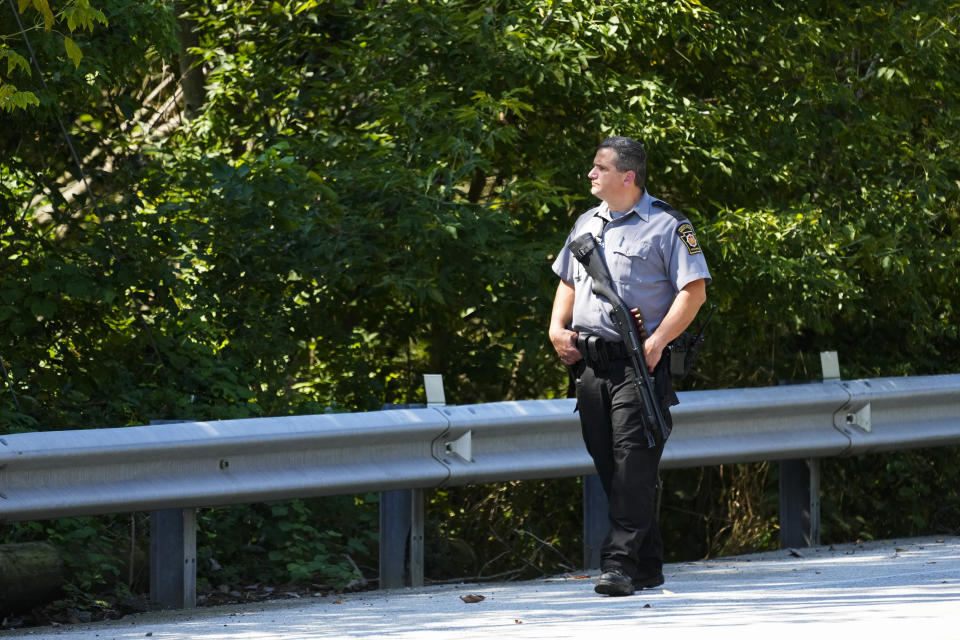 A law enforcement officer walks along the side of a road as the search for escaped convict Danelo Cavalcante continues in Pottstown, Pa., Tuesday, Sept. 12, 2023. (AP Photo/Matt Rourke)