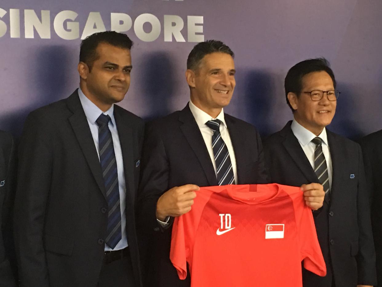 Newly-appointed Football Association of Singapore (FAS) technical director Joseph Palatsides (centre) holds up the national team jersey, flanked by FAS general secretary Yazeen Buhari (left) and FAS president Lim Kia Tong. (PHOTO: Chia Han Keong/Yahoo News Singapore)