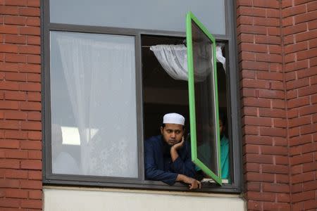 A man looks on from a window of Finsbury Park Mosque during a vigil near where to a van was driven at Muslims in Finsbury Park, North London, Britain, June 20, 2017. REUTERS/Marko Djurica