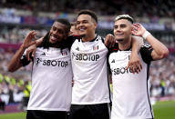 Fulham's Andreas Pereira, right, celebrates with team-mates Rodrigo Muniz and Alex Iwobi after scoring their side's second goal during the English Premier League soccer match between West Ham United and Fulham, at the London Stadium, London, Sunday April 14, 2024. (John Walton/PA via AP)