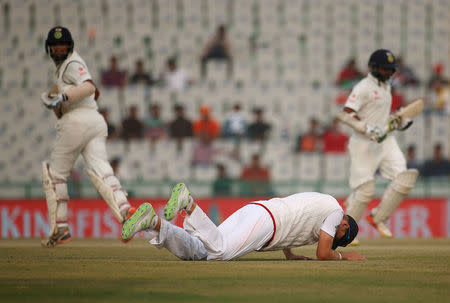 India's Cheteshwar Pujara (L) and Parthiv Patel (R) run between the wickets as England's Joe Root lies on the ground. India v England - Third Test cricket match - Punjab Cricket Association Stadium, Mohali, India - 29/11/16. REUTERS/Adnan Abidi