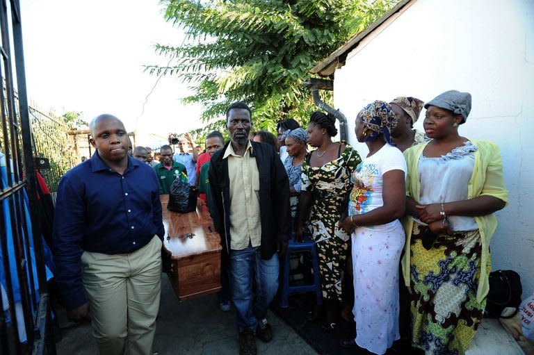 Relatives and friends carry the coffin of Mido Macia to his home in Daveyton on March 8, 2013 for people to pay their last respects before the coffin leaves South Africa for Mozambique. Large numbers of mourners gathered in Mozambique to bury the taxi driver who died in police custody in South Africa after officers cuffed him to their van and dragged him through the streets