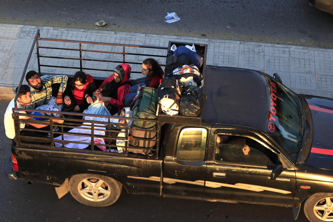 Ciudadanos libaneses huyendo de las aldeas del sur en medio de los continuos ataques aéreos israelíes sentados en una camioneta en una carretera que conecta Sidon con la ciudad de Beiru. (Foto AP/Mohammed Zaatari)