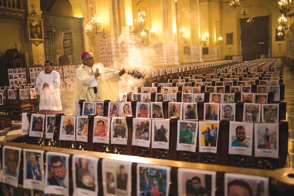 During the Corpus Christi mass in Lima's main cathedral, Archbishop Carlos Castillo swings a censer, spreading incense before more than 5,000 portraits of people who died from Covid-19, Peru, June 14, 2020. At this time, more than 225,000 had been infected in the country. (Photo: Rodrigo Abd/AP)