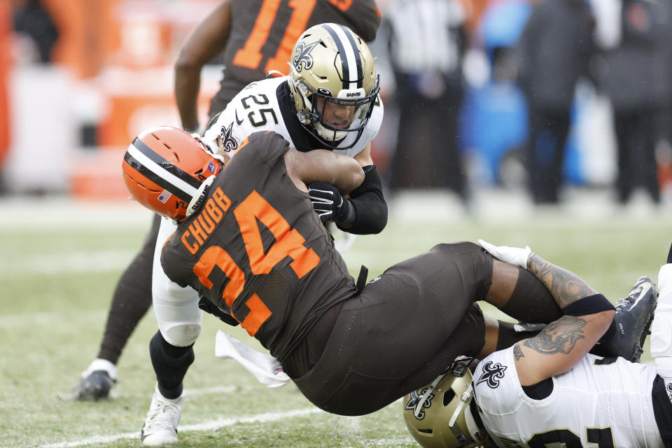 Cleveland Browns running back Nick Chubb (24) is tackled by New Orleans Saints safety Daniel Sorensen (25) during the second half of an NFL football game, Saturday, Dec. 24, 2022, in Cleveland. (AP Photo/Ron Schwane)