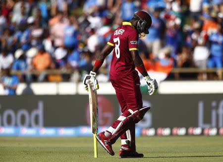 West Indies batsman Jonathan Carter walks off the field after being caught out by India's Mohammed Shami during their Cricket World Cup match in Perth, March 6, 2015. REUTERS/David Gray