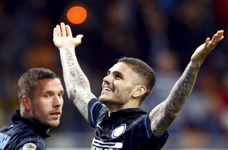 Inter Milan's Mauro Icardi (R) celebrates with teammate Lukas Podolski after scoring against AS Roma during their Serie A soccer match at the San Siro stadium in Milan, Italy, April 25, 2015. REUTERS/Stefano Rellandini