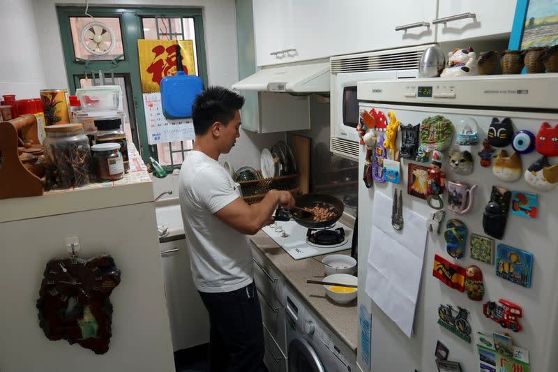 Fitness trainer Mike Lee demonstrates making a dish with plant-based meat Omnipork for the camera at his home in Hong Kong
