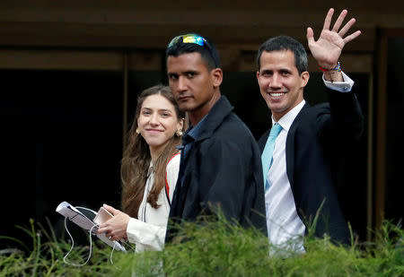 Venezuelan opposition leader and self-proclaimed interim president Juan Guaido waves to his supporters next to his wife Fabiana Rosales outside their house in Caracas, Venezuela January 31, 2019. REUTERS/Carlos Garcia Rawlins