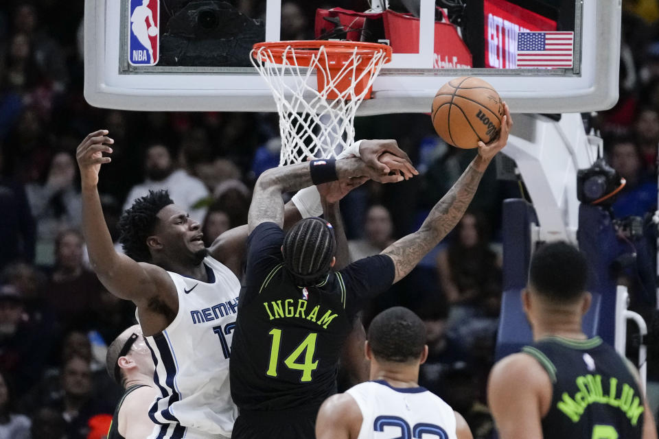 New Orleans Pelicans forward Brandon Ingram (14) is fouled by Memphis Grizzlies forward Jaren Jackson Jr. as he goes to the basket in the first half of an NBA basketball game in New Orleans, Tuesday, Dec. 19, 2023. (AP Photo/Gerald Herbert)