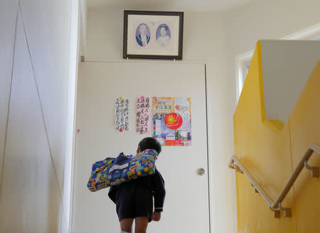 FILE PHOTO - A student stops to bow to a portrait of Japanese former Emperor Hirohito and Empress Kojun at Tsukamoto kindergarten in Osaka, Japan, November 30, 2016. REUTERS/Ha Kwiyeon/File Photo