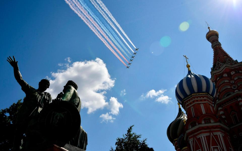 Russian Sukhoi Su-25 assault aircrafts release smoke in the colours of the Russian flag while flying over Red Square during a military parade - Alexander Nemenov/AFP