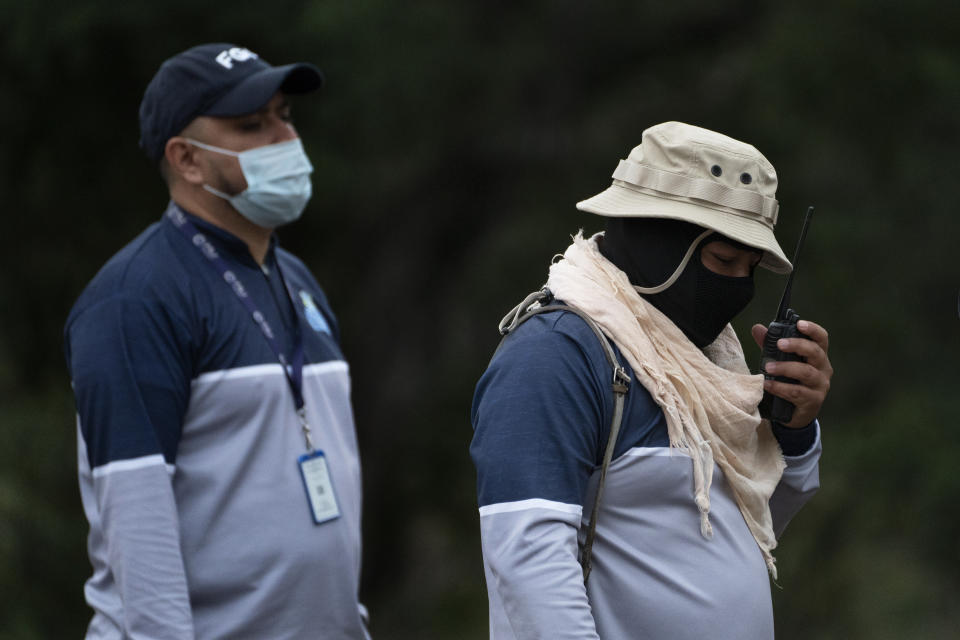 Jorge Macias, head of the Tamaulipas state search commission, uses a two-way radio while walking on a field on the outskirts of Ciudad Victoria, Mexico, Thursday, Feb. 3, 2022. Macías’ state commission has 22 positions budgeted, but has only filled a dozen slots. The issue isn’t money but the difficulty in finding applicants who pass background checks. (AP Photo/Marco Ugarte)