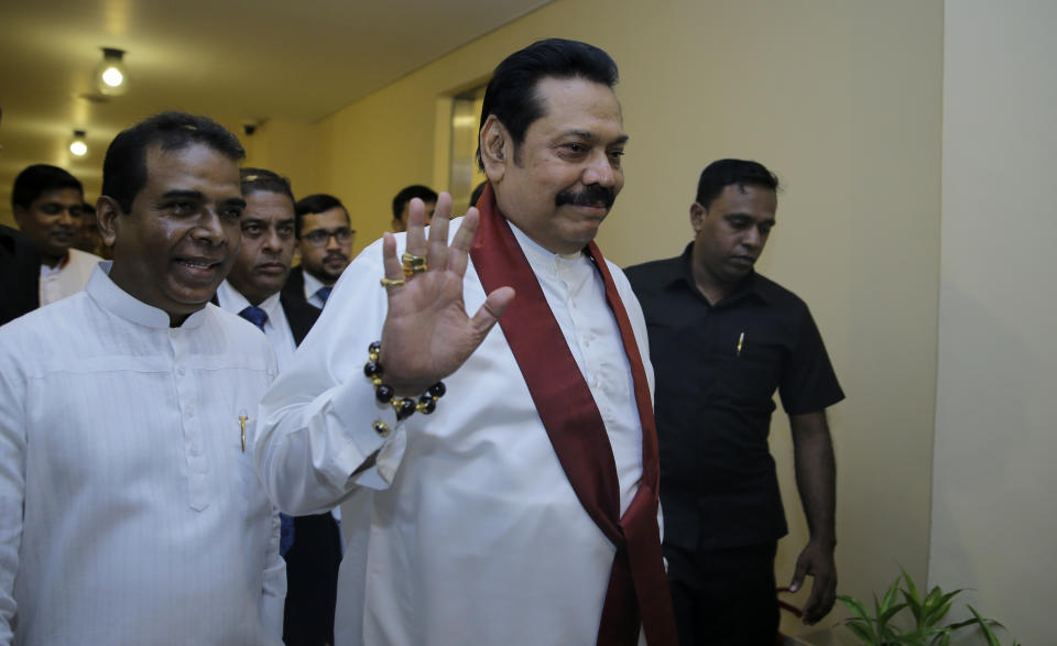 FILE - In this Nov. 29,2018, file photo, Sri Lanka's disputed Prime Minister Mahinda Rajapaksa, gestures as he arrives for a meeting with his supporting lawmakers at the parliamentary complex in Colombo, Sri Lanka. A Sri Lankan lawmaker said that the disputed Prime Minister Rajapaksa will resign Saturday to end the country's political crisis. (AP Photo/Eranga Jayawardena, File)