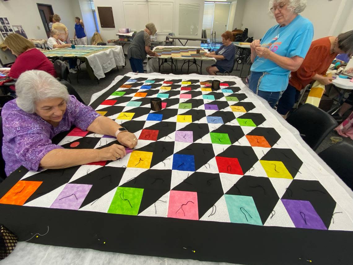 Members of The Hills Quilting Ladies work to complete quilts with leftover material from Verna Mae Brashear.