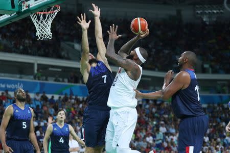 Aug 14, 2016; Rio de Janeiro, Brazil; United States center Demarcus Cousins (12) shoots the ball as France center Joffrey Lauvergne (7) defends during the men's preliminary round in the Rio 2016 Summer Olympic Games at Carioca Arena 1. Jeff Swinger-USA TODAY Sports