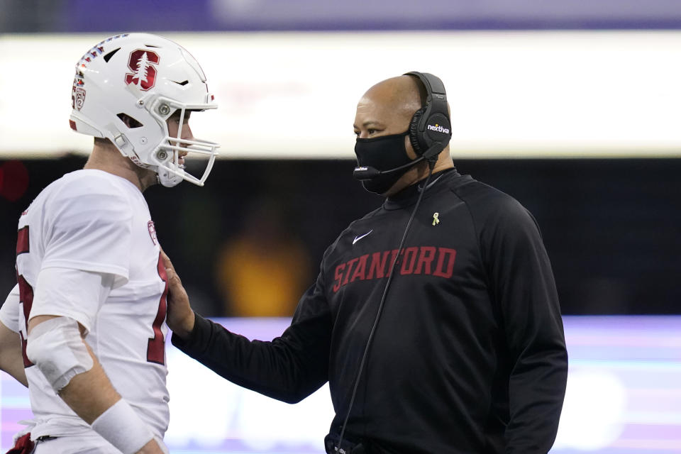 Stanford coach David Shaw, right, talks with quarterback Davis Mills during a timeout in the second half of the team's NCAA college football game against Washington on Saturday, Dec. 5, 2020, in Seattle. Stanford won 31-26. (AP Photo/Elaine Thompson)