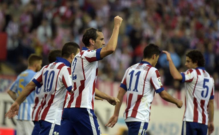 Atletico Madrid's Diego Godin (C) celebrates with teammates after scoring a goal during their Spanish La Liga match, at the Vicente Calderon stadium in Madrid, on November 22, 2014