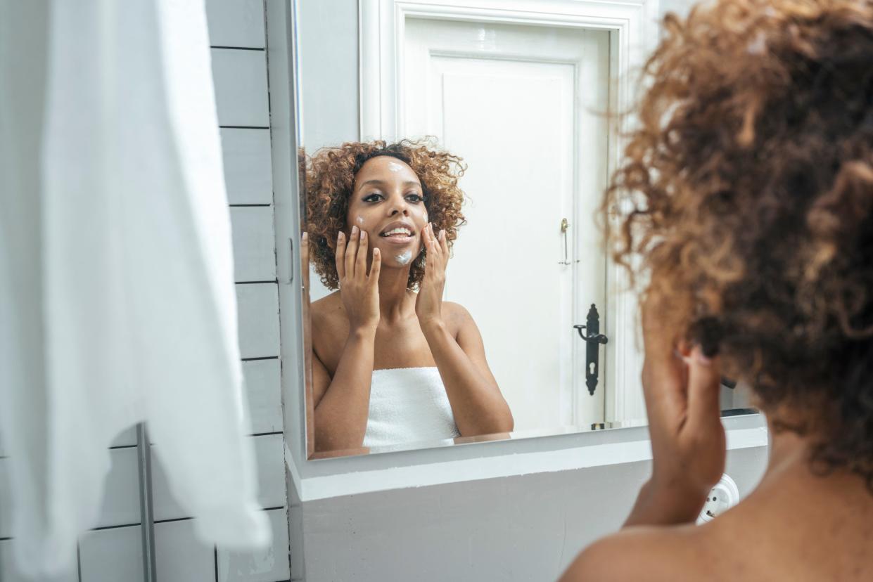 woman moisturizing face