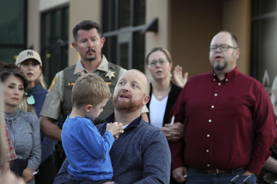 Pastor Matt Mizell, center, leads a prayer vigil as Farmington Mayor Nate Duckett, right, and dozens of community members gather following a deadly shooting in Farmington, N.M., Monday, May 15, 2023. (AP Photo/Susan Montoya Bryan)